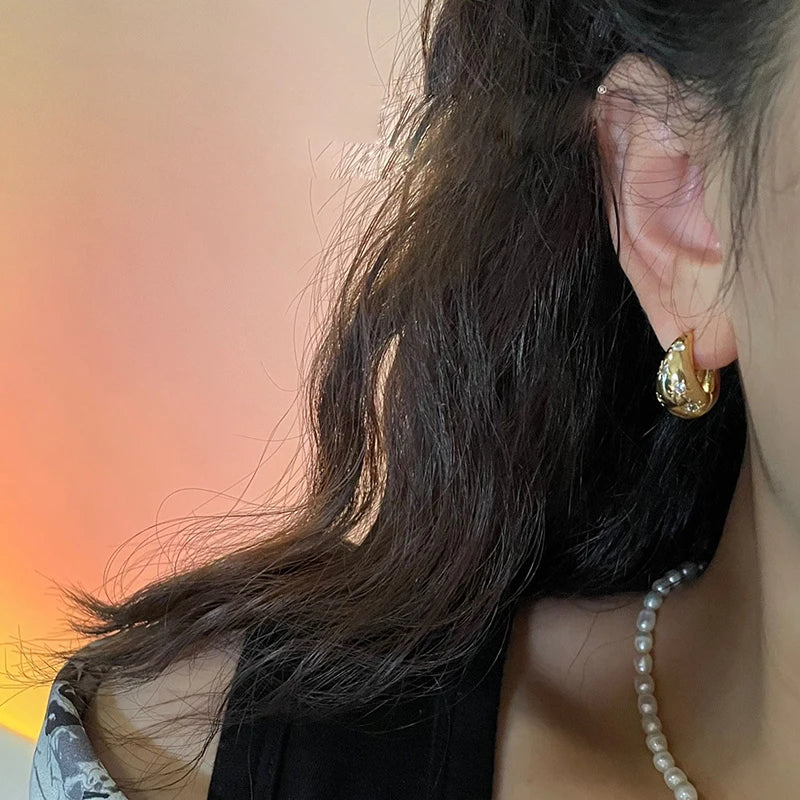 Boucles d'oreilles créoles en goutte dorées avec étoiles