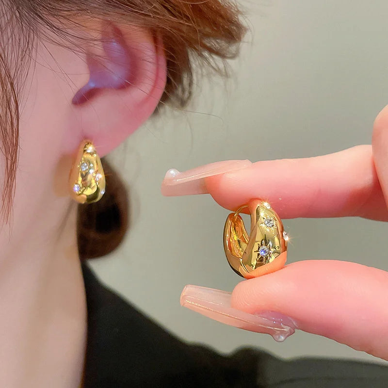 Boucles d'oreilles créoles en goutte dorées avec étoiles